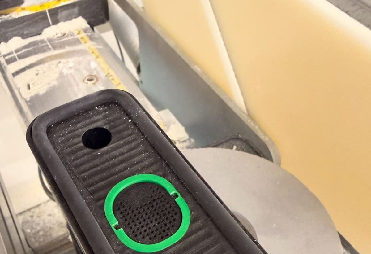 Close view of a black vacuum pod with a ribbed rubber top and a green replaceable rubber sealing strip