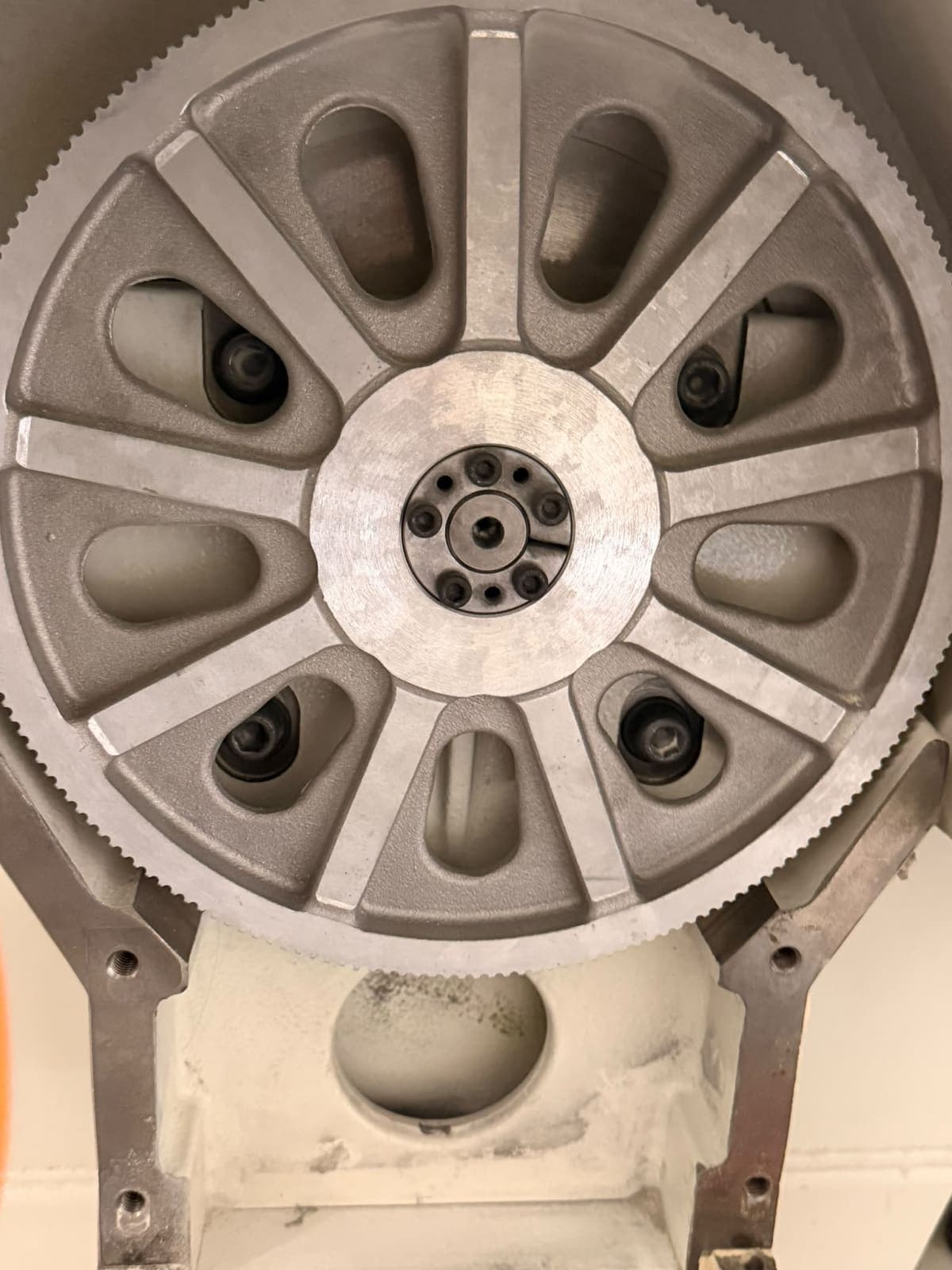 Close view of a large toothed aluminium pulley on a CNC machine